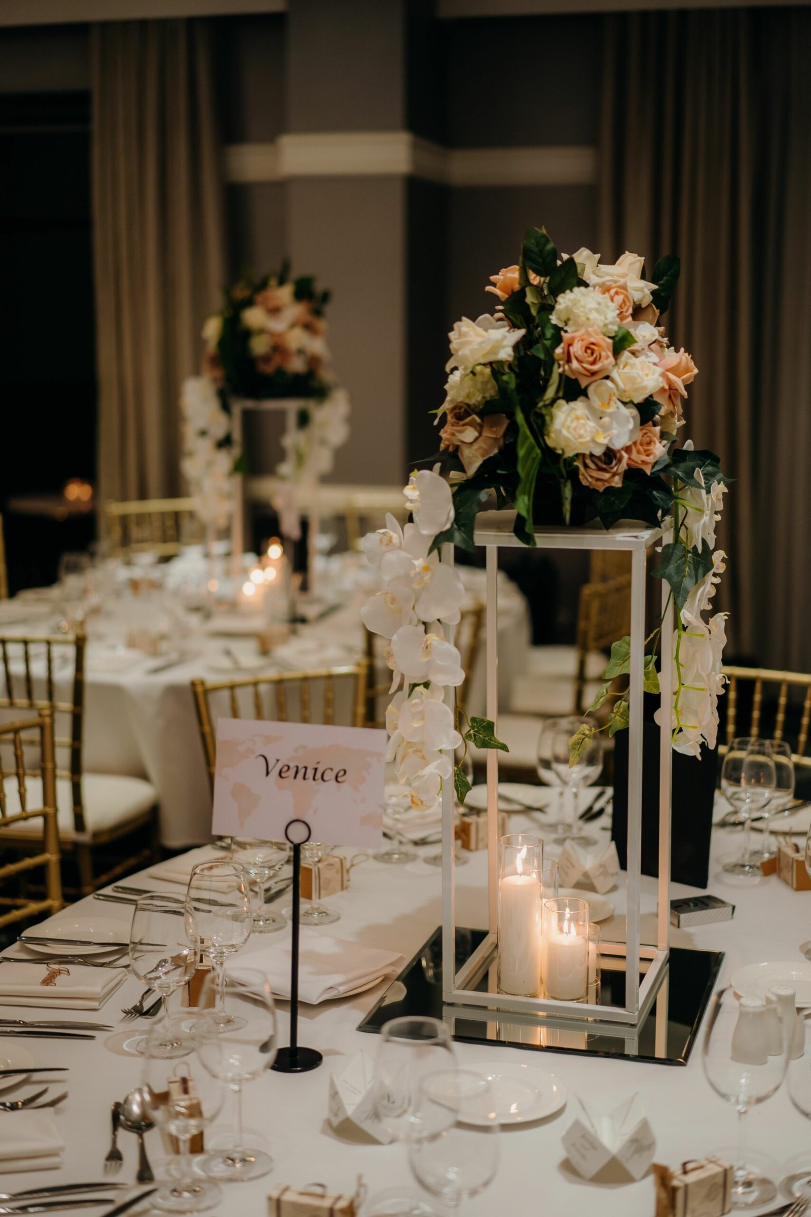 Vertical shot of a beautiful wedding venue table with candles and flowers